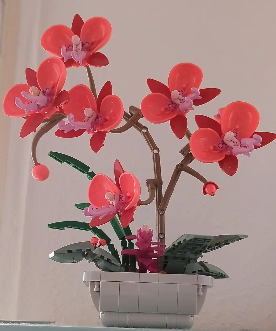 Red phalaenopsis orchids in a grey pot, all made from studded bricks