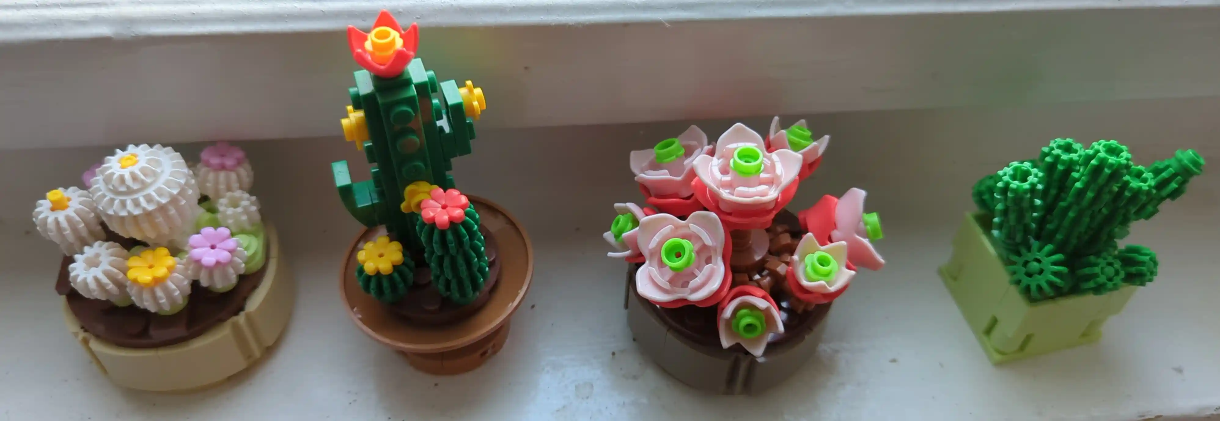 Four small potted succulents, made from studded bricks